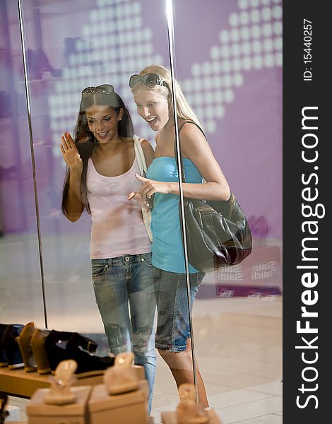 Young women looking through shop window