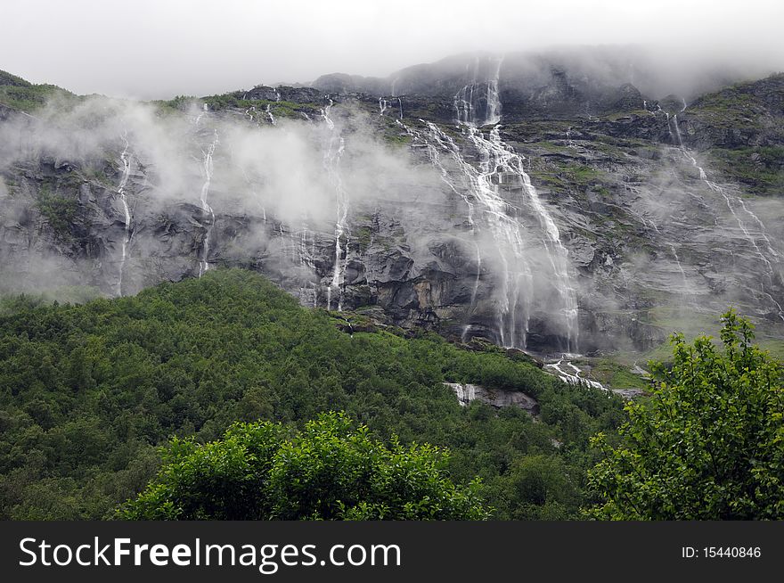 Water cascades through clouds above Lovatent lake in the Nordfjord region of Norway. Water cascades through clouds above Lovatent lake in the Nordfjord region of Norway