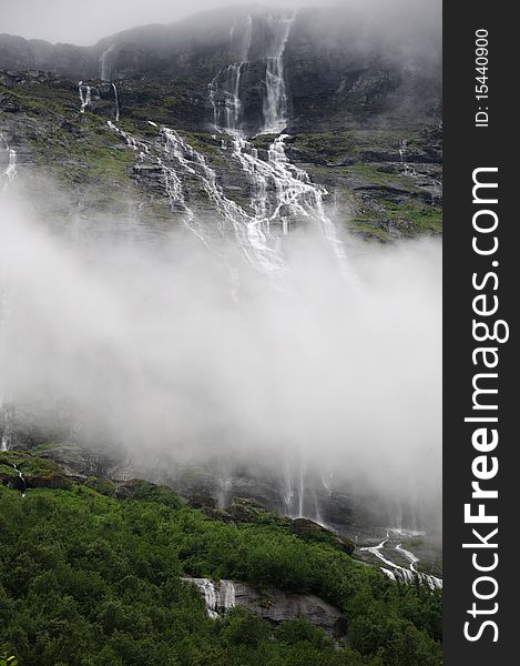 Water cascades through clouds above Lovatent lake in the Nordfjord region of Norway. Water cascades through clouds above Lovatent lake in the Nordfjord region of Norway