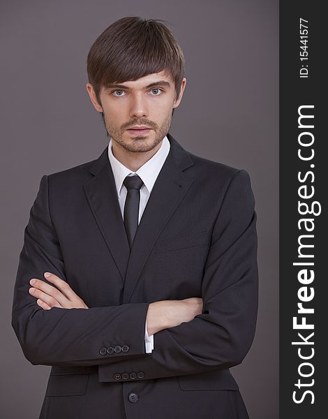Portrait of young businessman over grey background