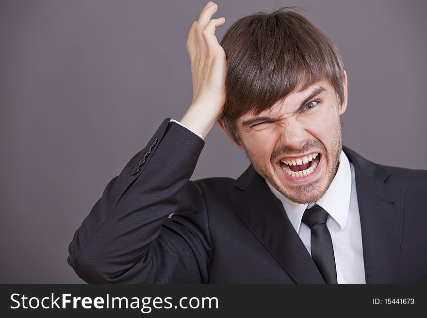 Frustrated and angry businessman over grey background. Frustrated and angry businessman over grey background