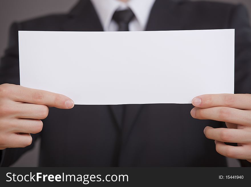 Businessman showing empty white board in the camera. Businessman showing empty white board in the camera