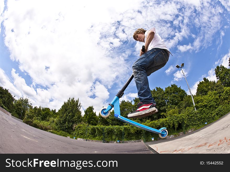 Boy with scooter is going airborne