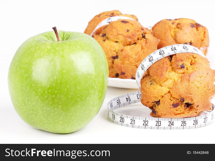 Green apple and cakes with measureing tape