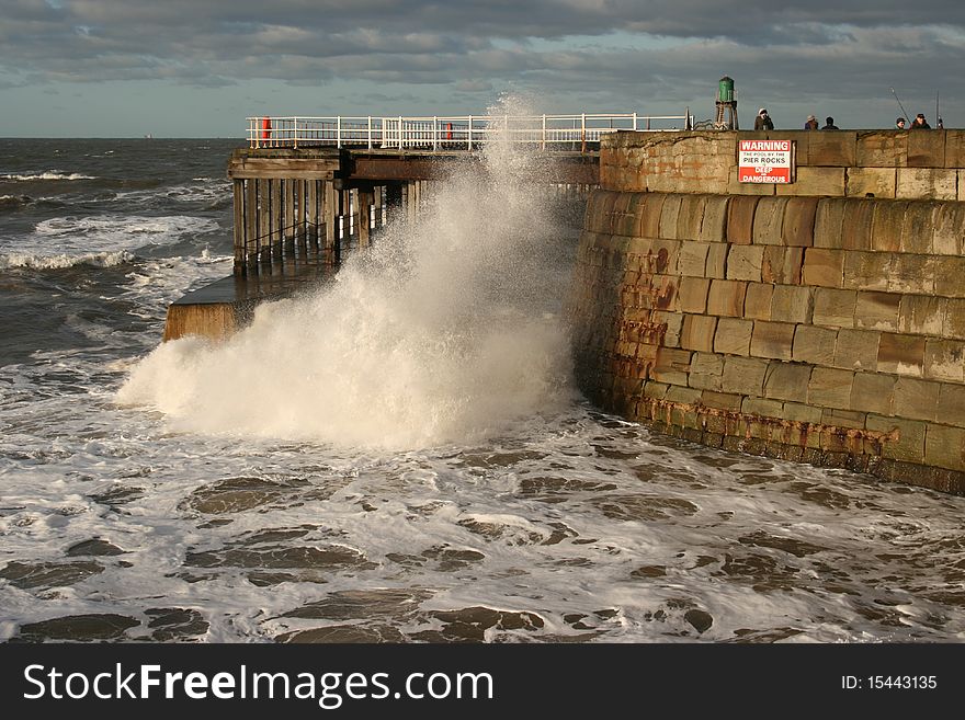 Wave crashing under Whitby pier