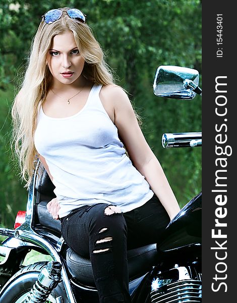 Shot of an attractive woman biker posing on her motorcycle. Shot of an attractive woman biker posing on her motorcycle.