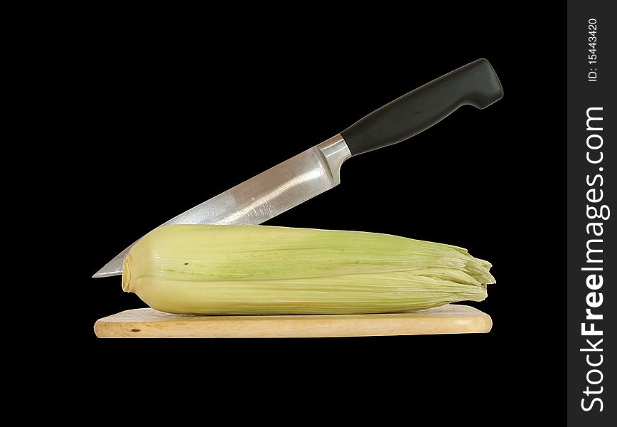 Still life with a natural corn cob with a knife and cutting board. In isolation