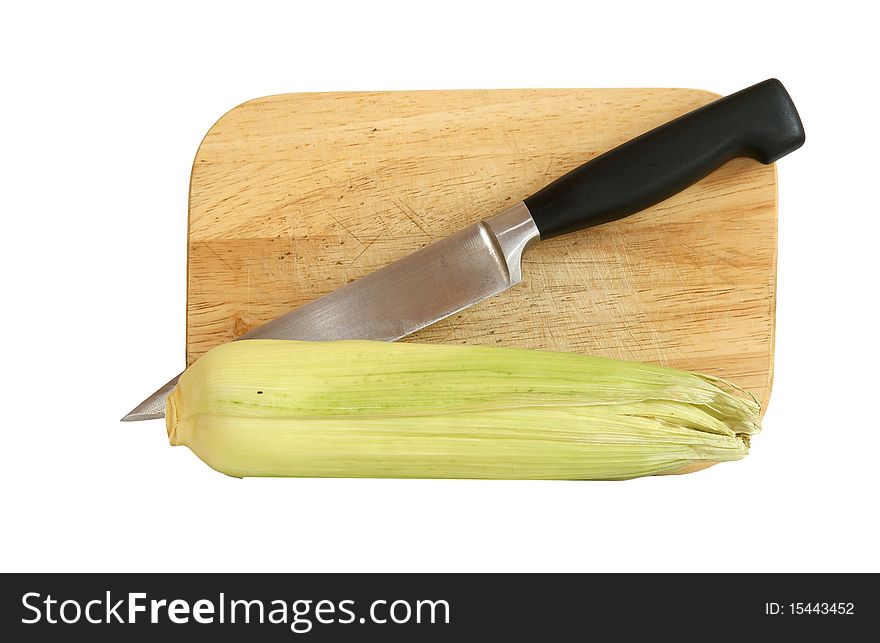 Still life with a natural corn cob with a knife and cutting board. In isolation