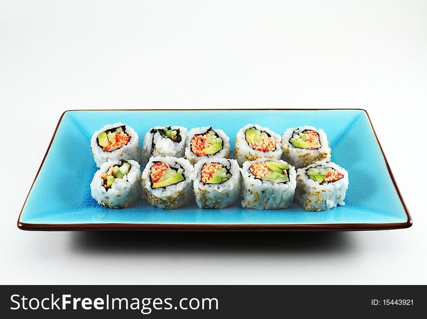 Fresh sushi lined up on a blue serving plate.
