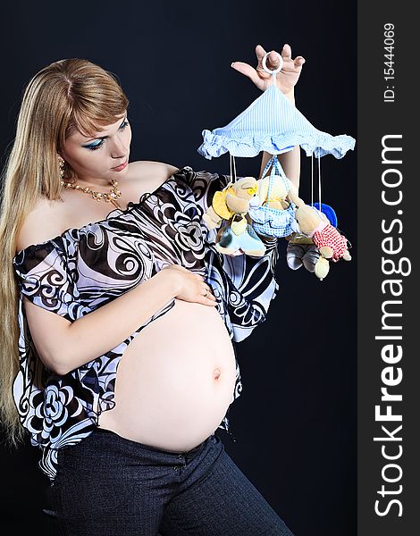 Portrait of pregnant woman posing against black background. Portrait of pregnant woman posing against black background.