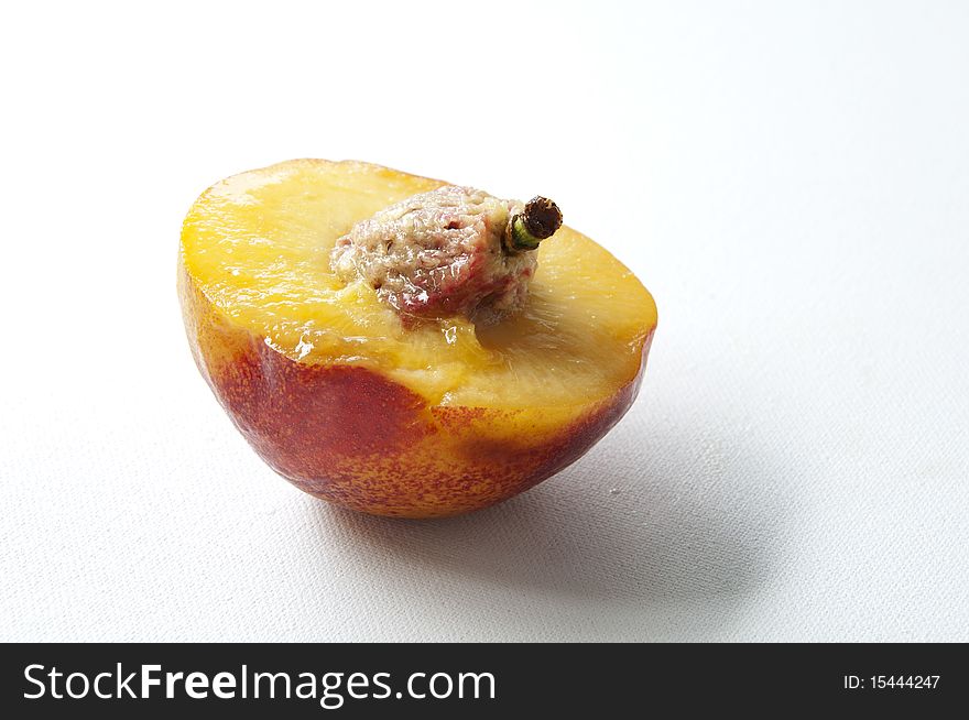 peach cut half and nut is exposed. peach cut half and nut is exposed