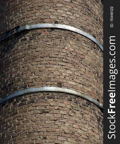 Old brick chimney fixed steel hoops. Old brick chimney fixed steel hoops