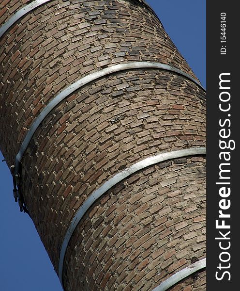 Old brick chimney fixed steel hoops. Old brick chimney fixed steel hoops