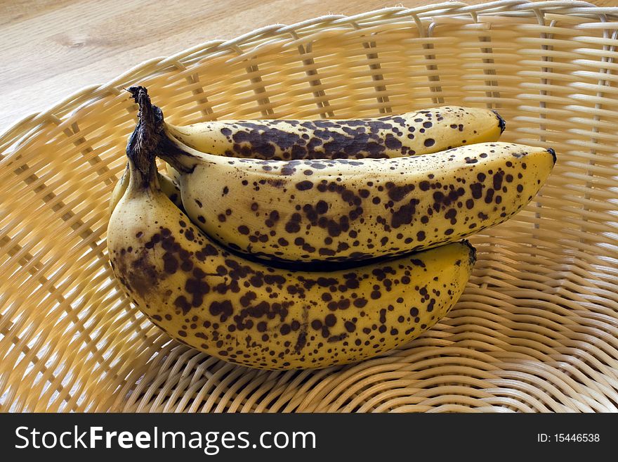 Ripe spotty bananas in a wicker basket. Ripe spotty bananas in a wicker basket