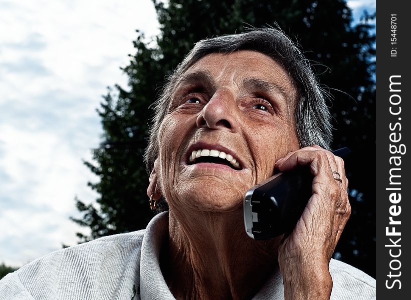 A senior woman enjoys a conversation on a cordless phone. A senior woman enjoys a conversation on a cordless phone.