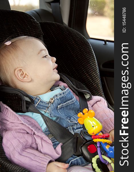 Little girl sitting in a car seat. Little girl sitting in a car seat