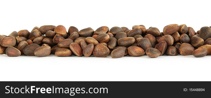 Not peeled pine nuts closeup, isolated on a white background