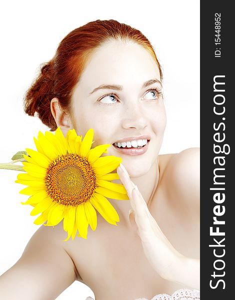 The image of a beautiful smiling girl with a sunflower in the hands
