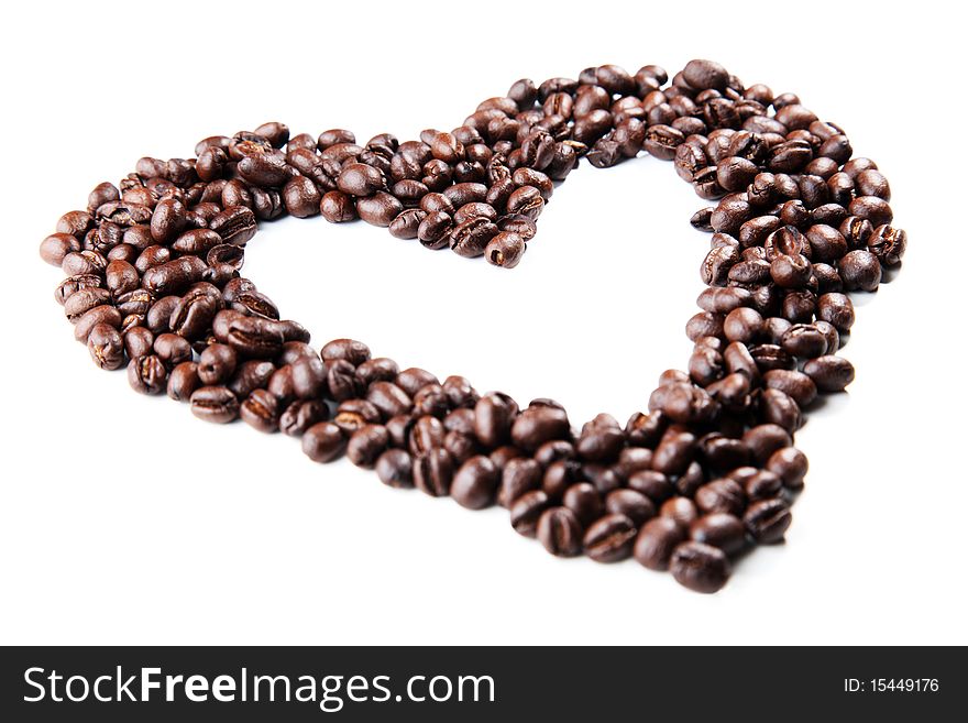 Coffee beans in the shape of a heart, closeup on white background