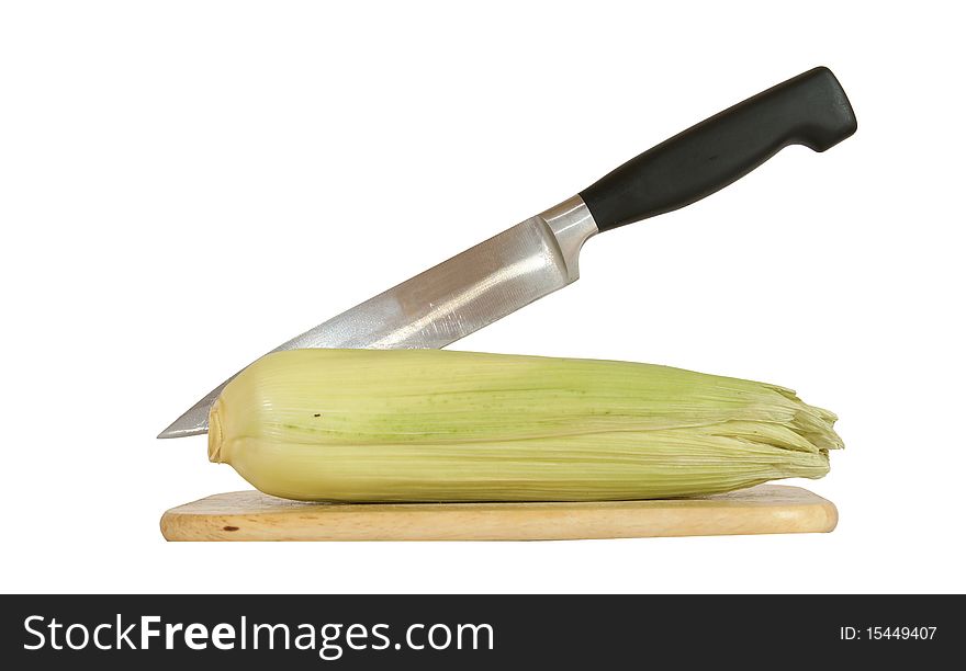 Still life with a natural corn cob with a knife and cutting board. In isolation