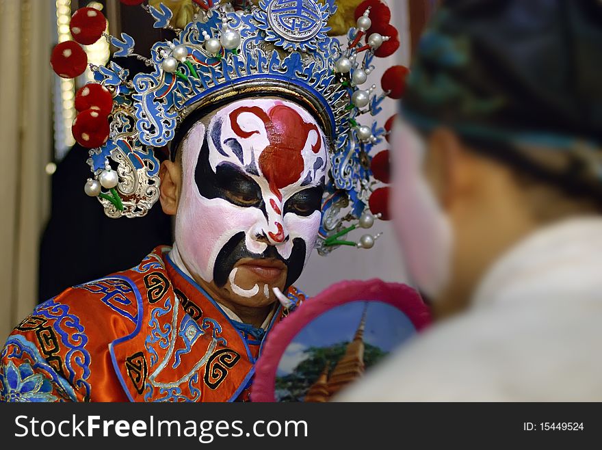 China opera actor is facial painting backstage. China opera actor is facial painting backstage