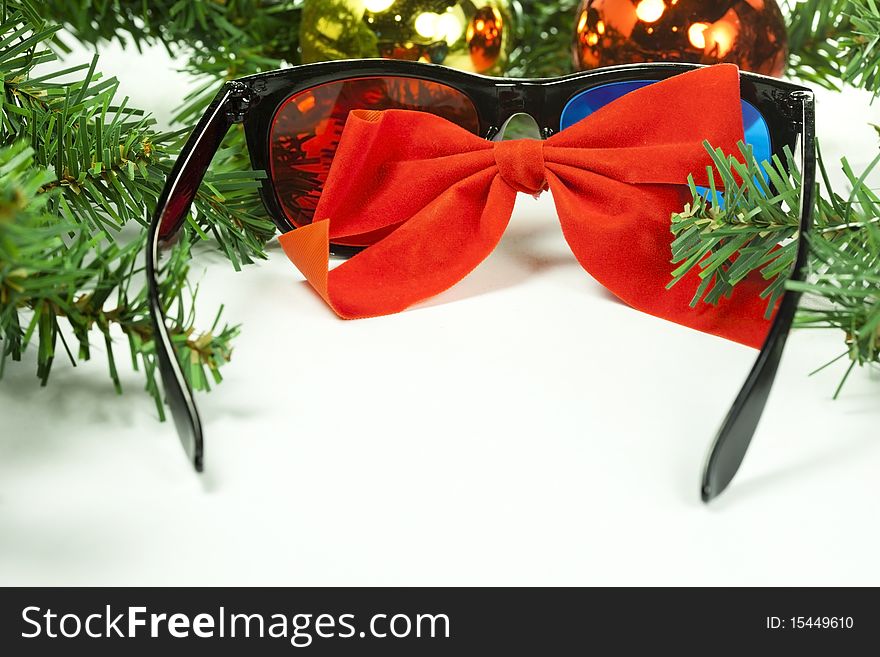 3D Anaglyph Glasses with a Christmas Bow and Christmas Tree decorations surrounding it. 3D Anaglyph Glasses with a Christmas Bow and Christmas Tree decorations surrounding it