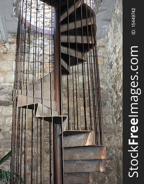 Ancient metallic spiral staircase in stone building