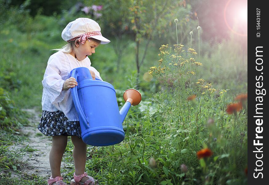 Beautiful white girl watering flowers from watering can. Beautiful white girl watering flowers from watering can