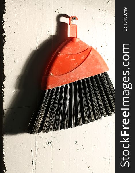 A broom hanging on a wall in a darkroom. Looks a bit like an overexposed film photo. A broom hanging on a wall in a darkroom. Looks a bit like an overexposed film photo