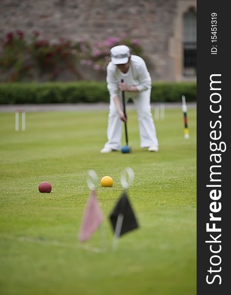 A player concentrating on a strike during game of croquet