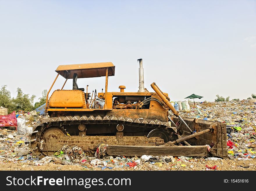 Bulldozer in the middle of garbage dump