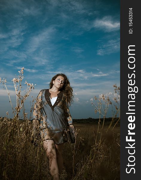 Young beautiful woman walking through meadow plants. Young beautiful woman walking through meadow plants