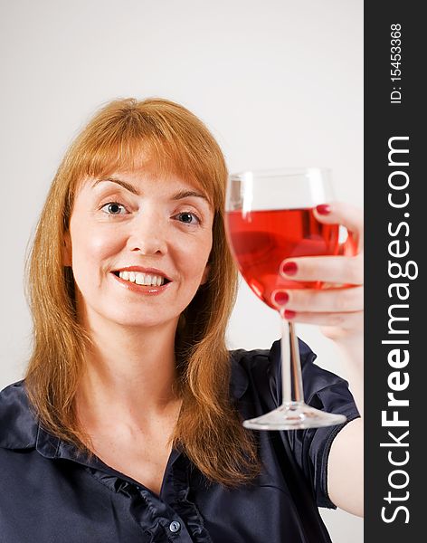 A vertical image of a pretty young woman toasting with a glass of red wine. A vertical image of a pretty young woman toasting with a glass of red wine
