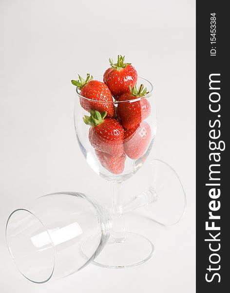 A vertical image of fresh succulent strawberries in a wine glass. A vertical image of fresh succulent strawberries in a wine glass