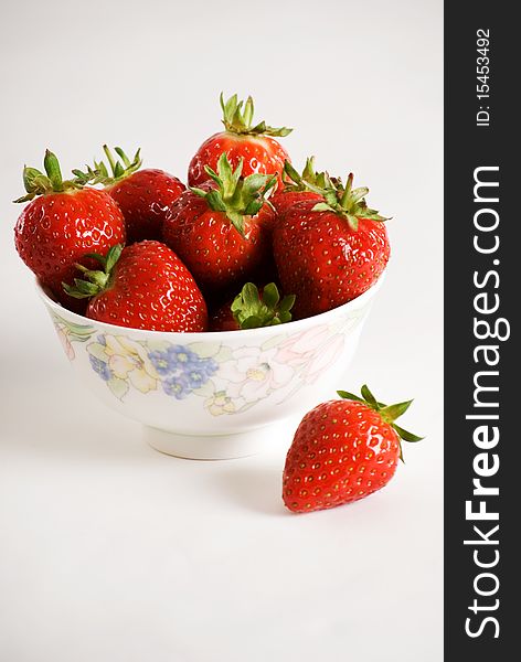 A vertical image of a bowl of fresh strawberries. A vertical image of a bowl of fresh strawberries