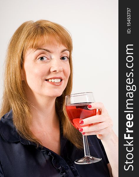 A vertical image of a pretty young woman drinking a glass of red wine. A vertical image of a pretty young woman drinking a glass of red wine