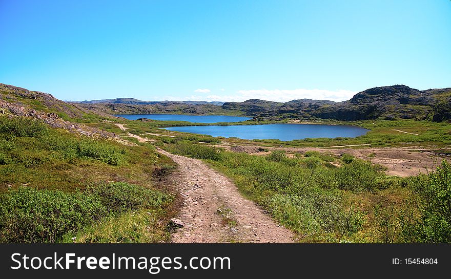 Two lakes surrounded by green hill. Coast of Kola Peninsula. Teriberka.