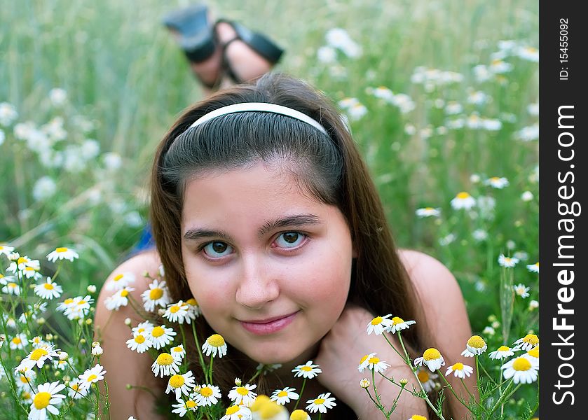 Young girl on chamomiles field. Shallow DOF