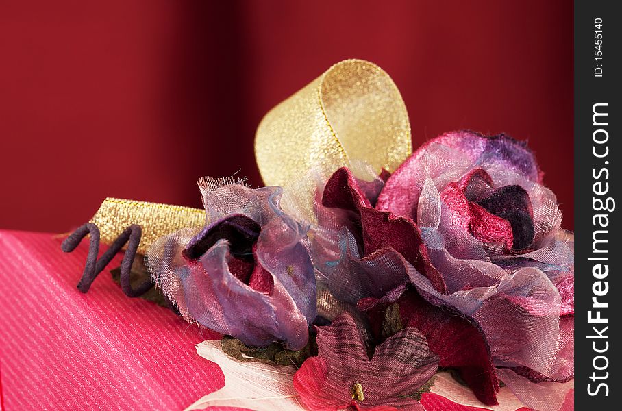 Close-up view of pink decorated Christmas present, over red background