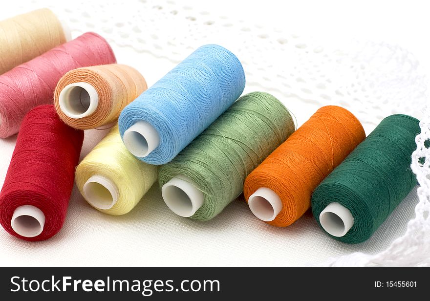 Multi-coloured threads on a white canvas. Multi-coloured threads on a white canvas