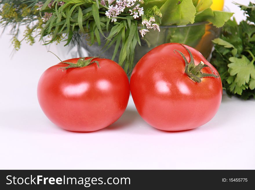 Fresh tomato against plate with vegetables