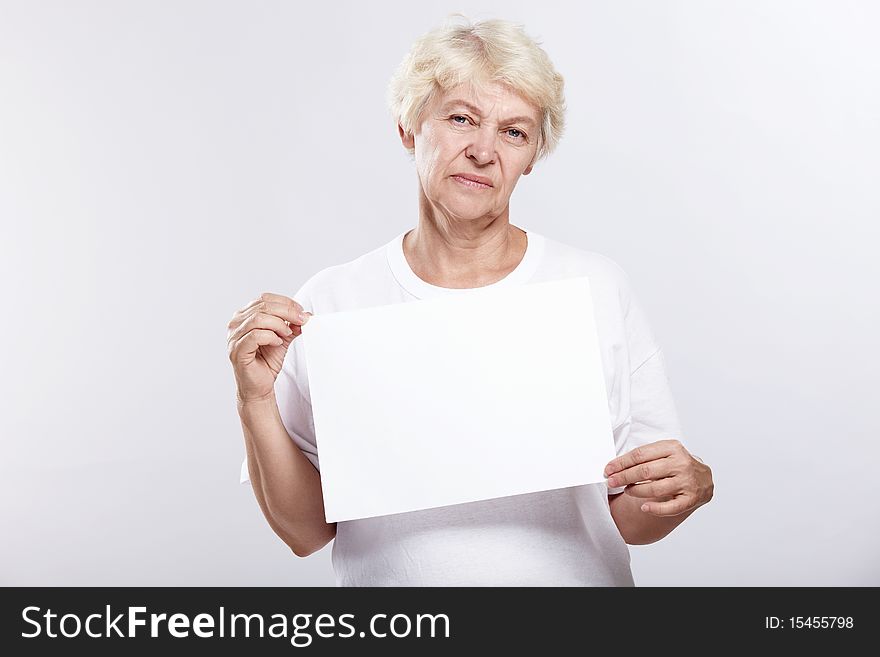 Mature woman is dissatisfied with an empty plate on a white background. Mature woman is dissatisfied with an empty plate on a white background