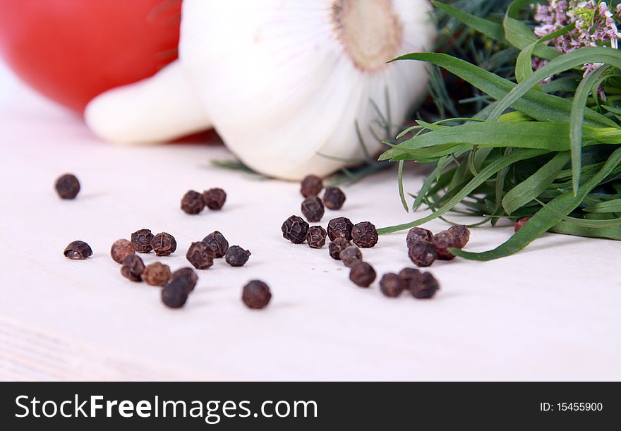 Close up of black peppercorns against vegetables