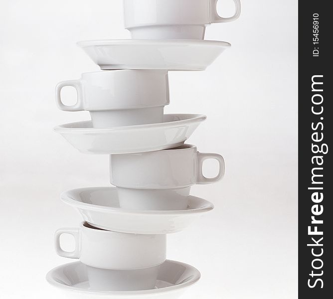 High key studio shot of cups balancing on top of eachother.