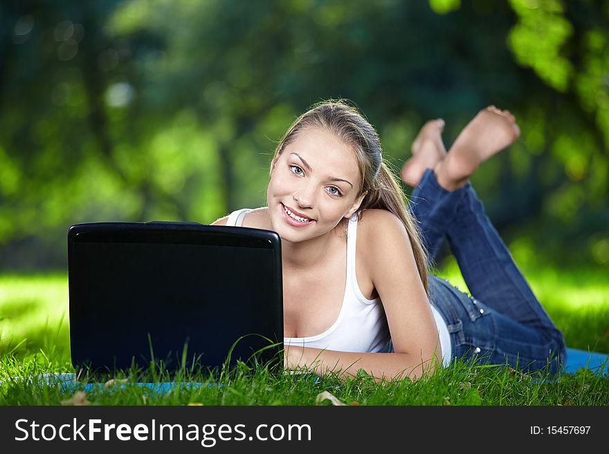 Attractive girl with a laptop in the park. Attractive girl with a laptop in the park