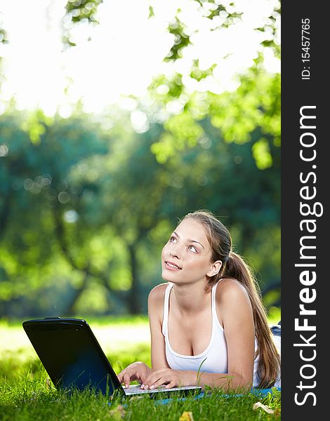 Young beautiful girl with a laptop in the park. Young beautiful girl with a laptop in the park