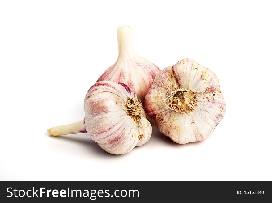 Three ripe garlics over a white background