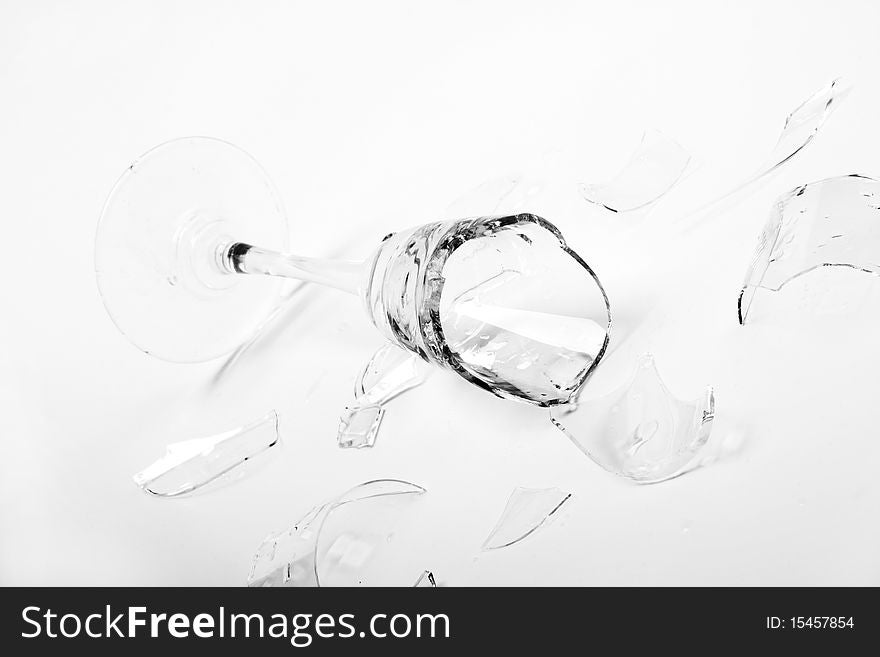 Broken wineglass on the white background. Black and white.