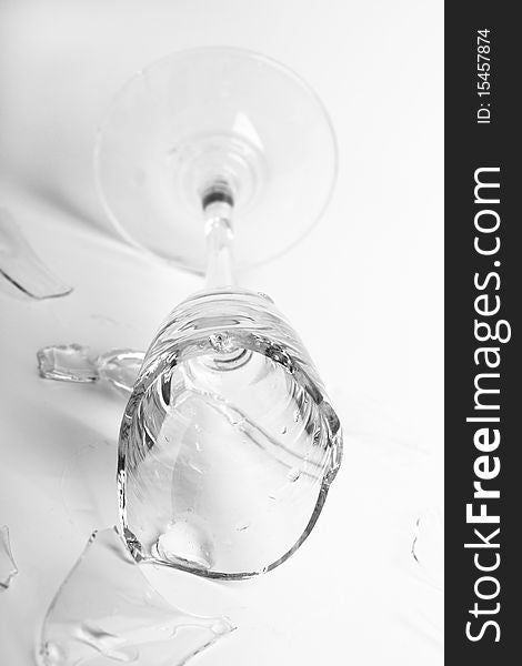 Broken wineglass on the white background. Black and white.