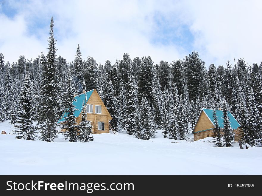 Two wooden houses in the winter in the mountains. Two wooden houses in the winter in the mountains